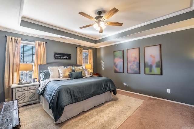 carpeted bedroom with crown molding, a tray ceiling, and ceiling fan