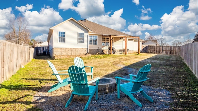 rear view of house featuring a lawn and a fire pit