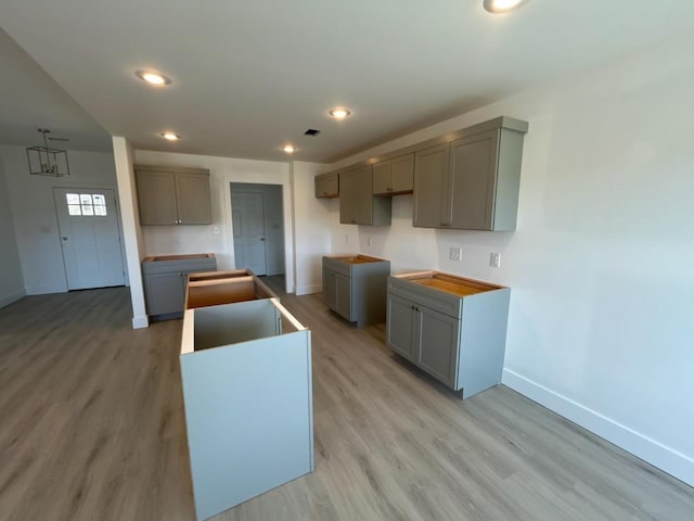 kitchen featuring light wood-type flooring, gray cabinetry, and a center island