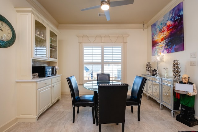 dining space featuring ceiling fan and crown molding