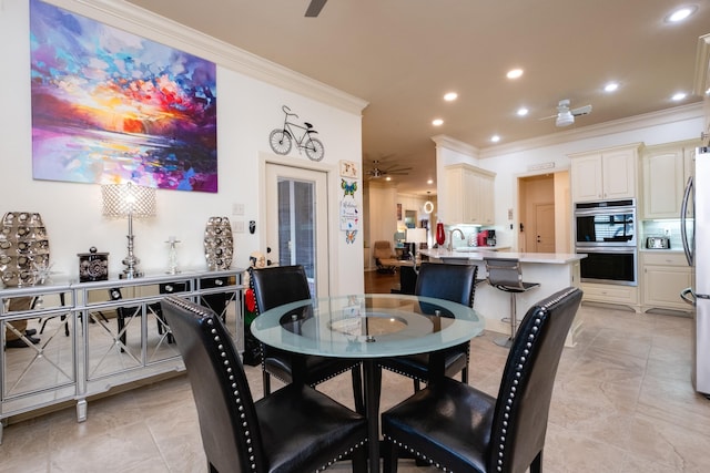 dining room with ornamental molding, ceiling fan, and sink