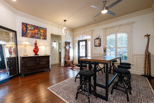 dining room with ceiling fan, ornamental molding, and dark wood-type flooring