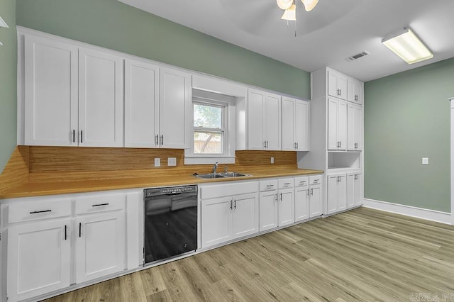 kitchen featuring black dishwasher, light hardwood / wood-style floors, sink, backsplash, and white cabinets