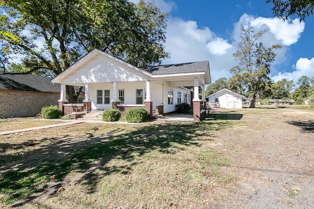 rear view of house with covered porch and a yard