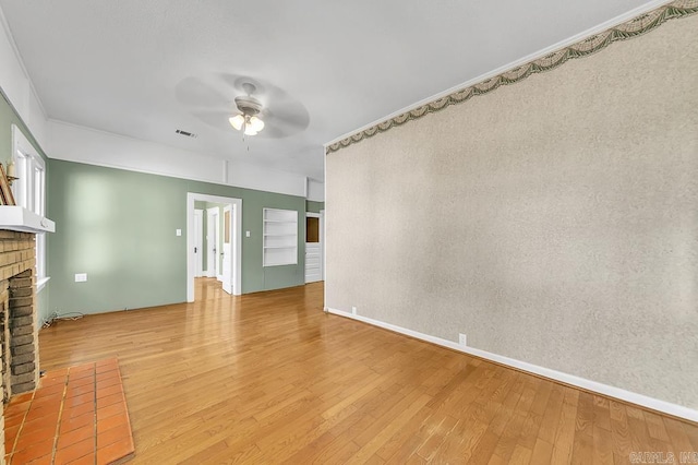 unfurnished living room featuring a fireplace, hardwood / wood-style flooring, and ceiling fan