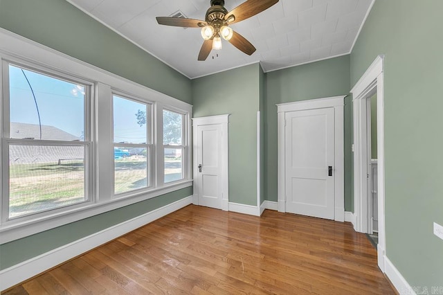 spare room with ceiling fan, light hardwood / wood-style floors, and crown molding