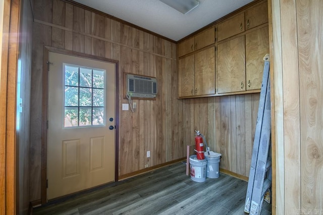 doorway featuring an AC wall unit, crown molding, dark hardwood / wood-style flooring, and wood walls