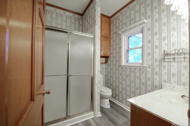 bathroom featuring hardwood / wood-style floors, toilet, vanity, and a shower with door