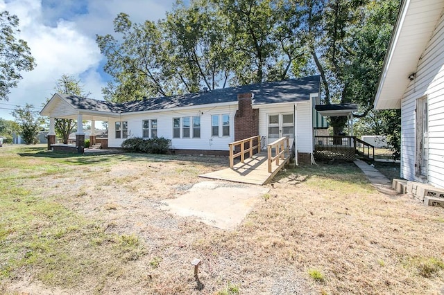 exterior space with a front lawn and a wooden deck