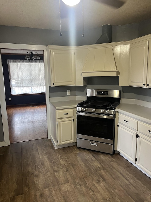 kitchen featuring dark hardwood / wood-style floors, premium range hood, white cabinets, and stainless steel gas stove