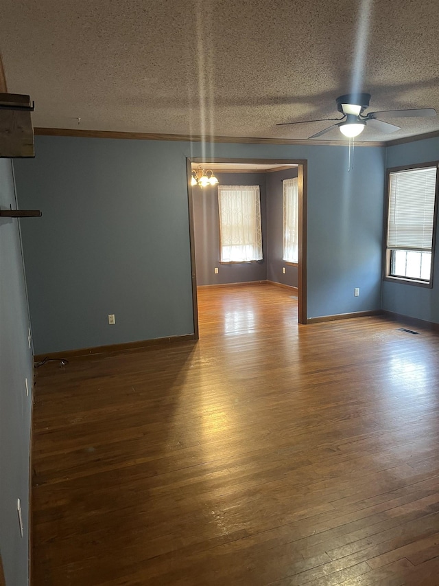 unfurnished room with ornamental molding, ceiling fan, wood-type flooring, and a textured ceiling