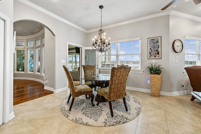 tiled dining room with ceiling fan with notable chandelier and crown molding