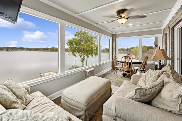 sunroom / solarium with ceiling fan and a water view