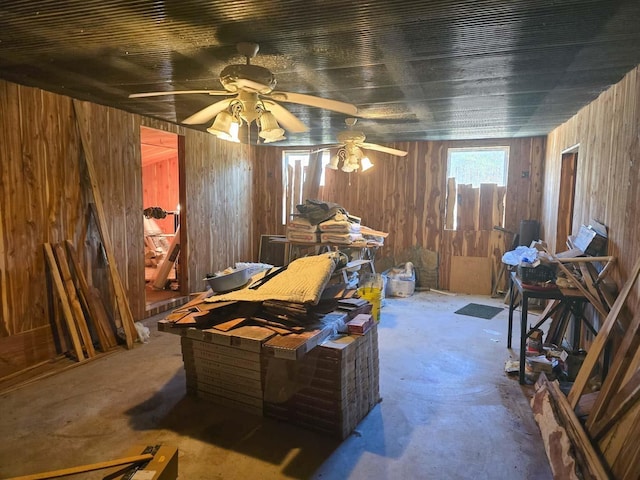 misc room featuring ceiling fan and wood walls