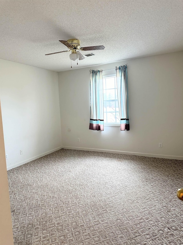 carpeted empty room featuring a textured ceiling and ceiling fan