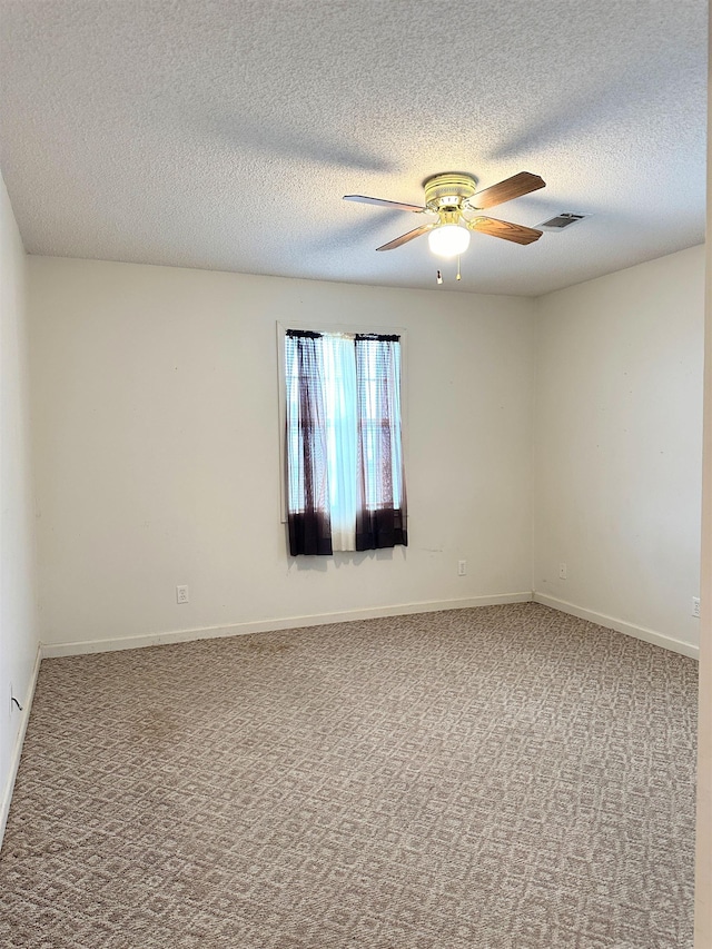 carpeted spare room with ceiling fan and a textured ceiling