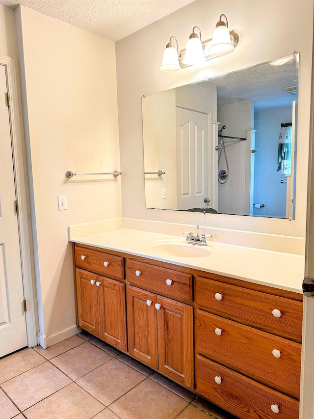 bathroom with vanity, tile patterned flooring, and a textured ceiling