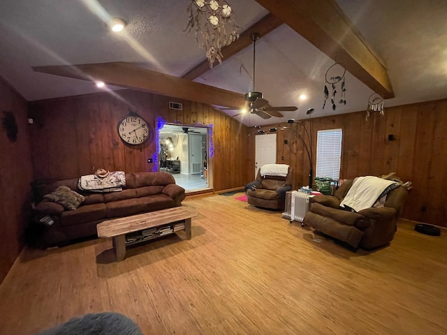 living room featuring wood walls, ceiling fan, lofted ceiling with beams, and wood-type flooring