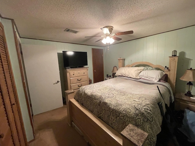 carpeted bedroom featuring a textured ceiling and ceiling fan