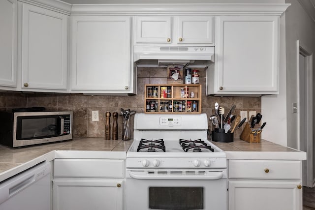 kitchen with white appliances, white cabinetry, tile countertops, and decorative backsplash