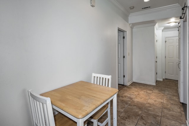 dining room featuring a barn door and crown molding