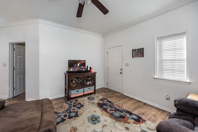 living room with hardwood / wood-style flooring, ceiling fan, and crown molding