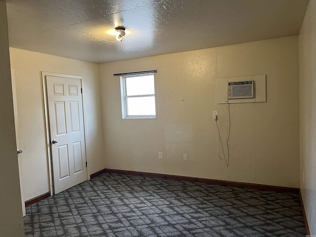 spare room featuring a wall mounted AC and a textured ceiling