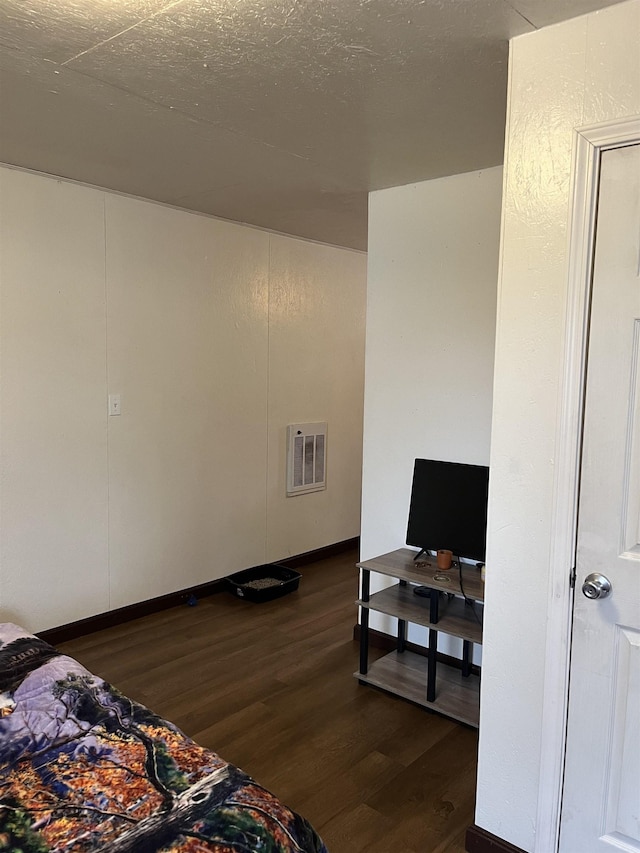 bedroom featuring a textured ceiling and dark wood-type flooring