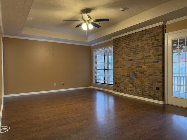 unfurnished room with a raised ceiling, a textured ceiling, plenty of natural light, and dark hardwood / wood-style floors