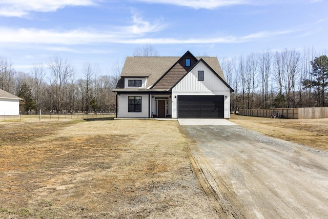 modern farmhouse featuring fence and driveway