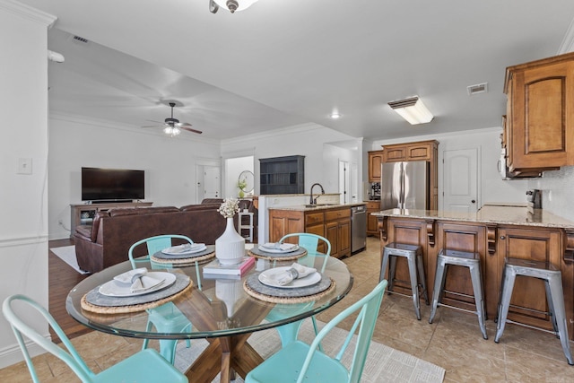 dining room featuring ceiling fan, sink, and ornamental molding