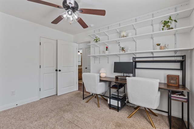 carpeted office space featuring ceiling fan