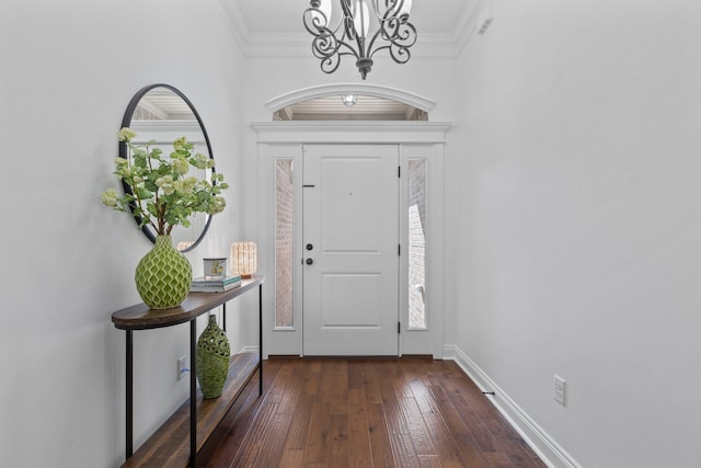 foyer entrance with a notable chandelier, crown molding, and dark hardwood / wood-style flooring