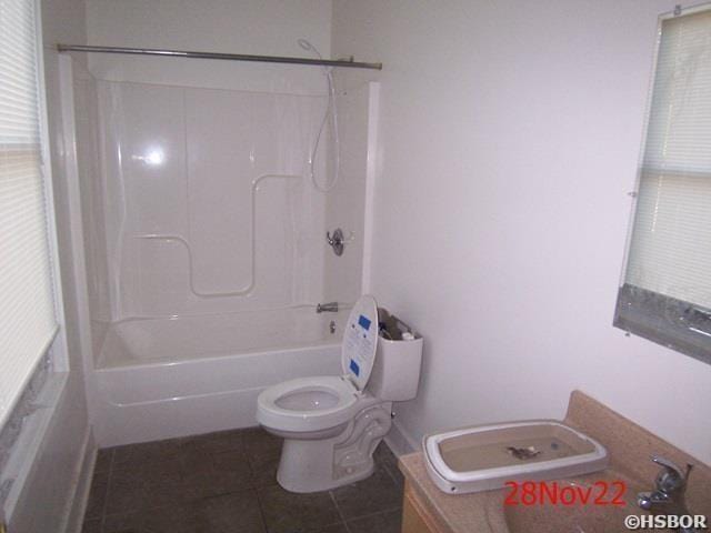 bathroom with tile patterned flooring, shower / tub combination, and toilet