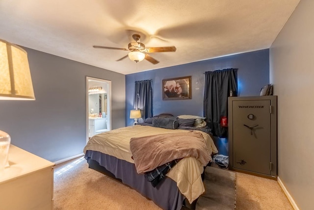 bedroom with ceiling fan, connected bathroom, and light colored carpet