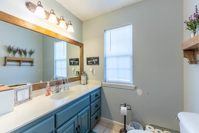 bathroom with toilet, vanity, and tile patterned flooring