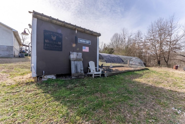 exterior space with a lawn and central air condition unit