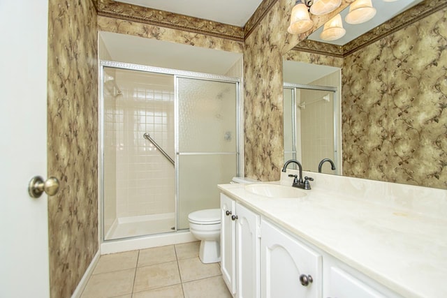 bathroom with tile patterned floors, toilet, vanity, and walk in shower