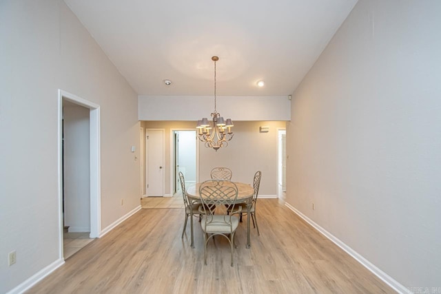 dining area with light wood-type flooring and a chandelier