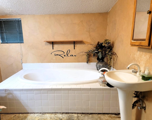 bathroom with a textured ceiling and tiled bath