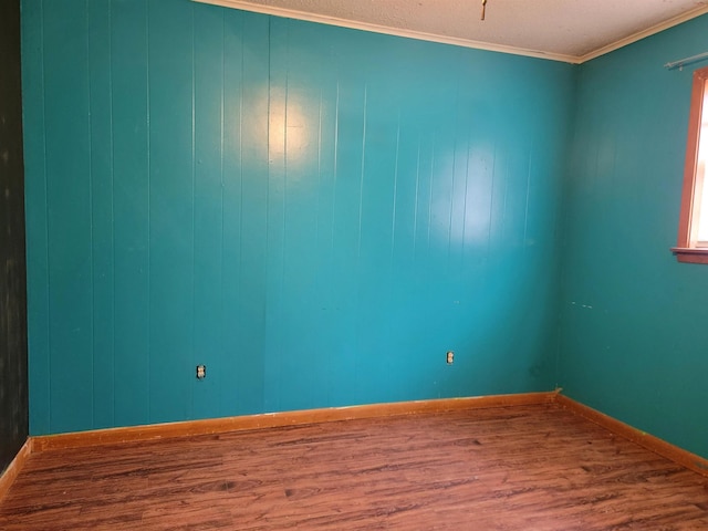 unfurnished room featuring hardwood / wood-style flooring, crown molding, and a textured ceiling