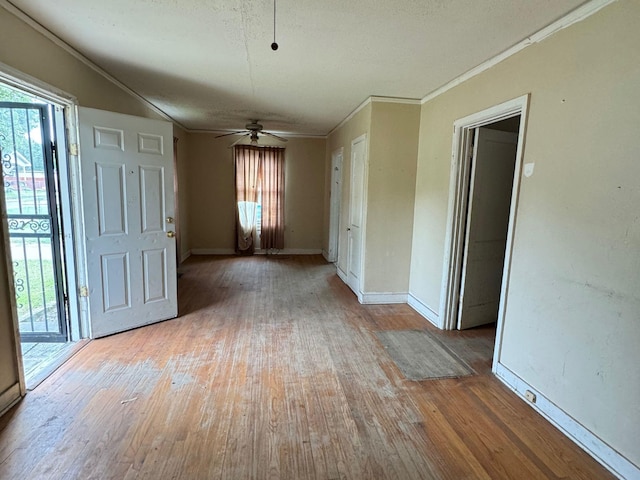 empty room featuring a textured ceiling, light hardwood / wood-style flooring, ceiling fan, and ornamental molding