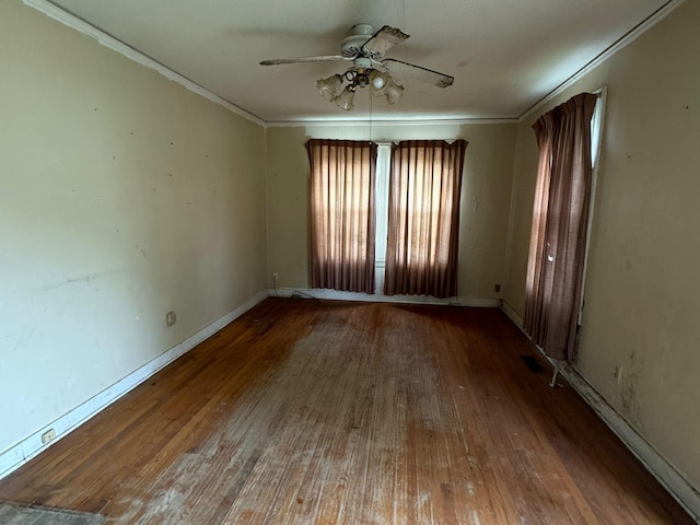 empty room with hardwood / wood-style flooring, ornamental molding, and ceiling fan