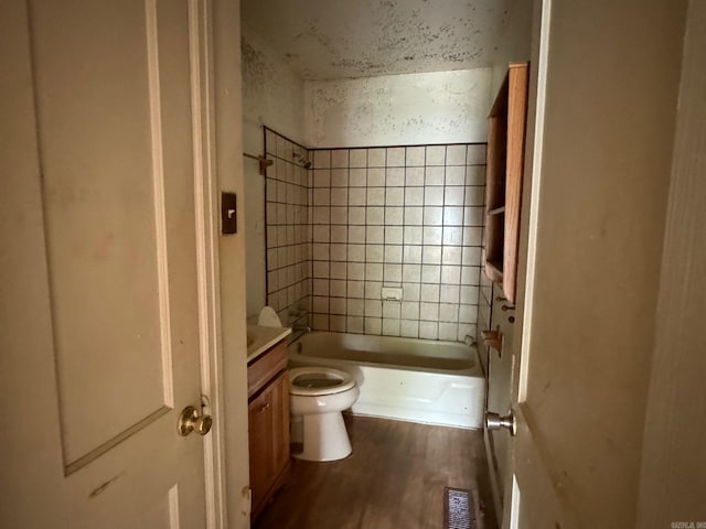 full bathroom featuring toilet, hardwood / wood-style flooring, vanity, and tiled shower / bath