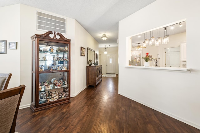 hallway featuring dark wood-type flooring and a textured ceiling