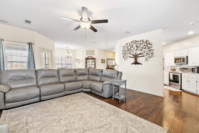 living room with a textured ceiling, dark hardwood / wood-style flooring, and ceiling fan with notable chandelier