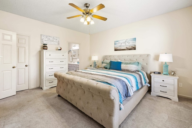 bedroom with light carpet, ceiling fan, and connected bathroom