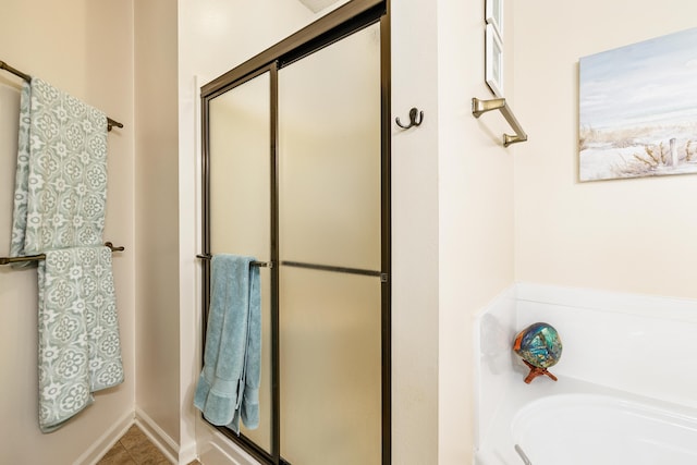 bathroom with separate shower and tub and tile patterned flooring