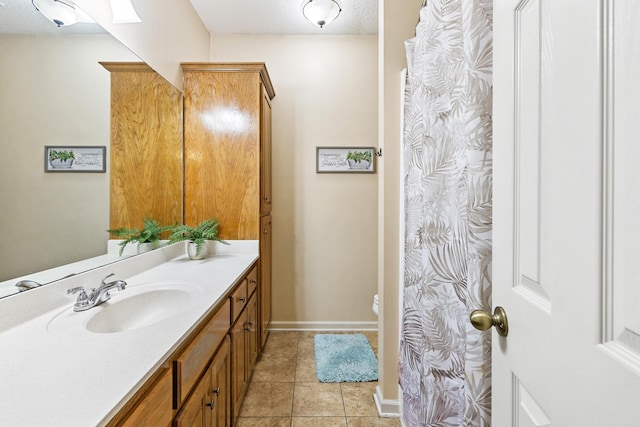 bathroom with tile patterned floors, toilet, a skylight, a textured ceiling, and vanity