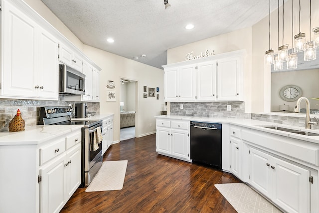 kitchen with decorative light fixtures, sink, stainless steel appliances, and white cabinets